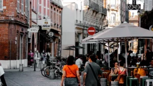 Terrasse de café animée avec des passants dans une rue typique du centre-ville de Toulouse