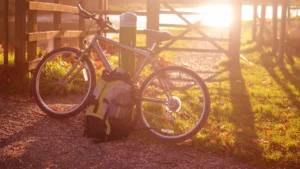 Un vélo équipé d'un sac à dos de voyage garé dans la nature au coucher du soleil