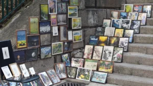 Des tableaux d'artistes locaux exposés sur les marches en pierre à Aix-en-Provence.