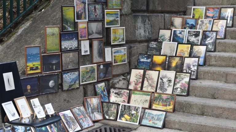 Des tableaux d'artistes locaux exposés sur les marches en pierre à Aix-en-Provence.