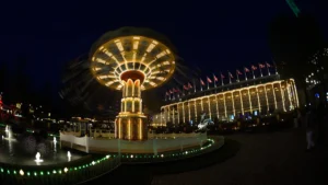 Manège de chaises volantes illuminé de nuit dans une ambiance de fête foraine