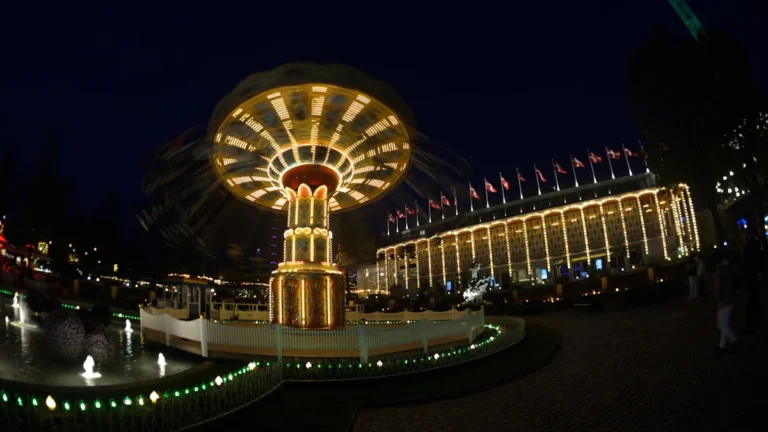 Manège de chaises volantes illuminé de nuit dans une ambiance de fête foraine
