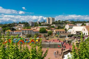 Structures gonflables colorées et tentes militaires sur une place publique entourée de bâtiments urbains.