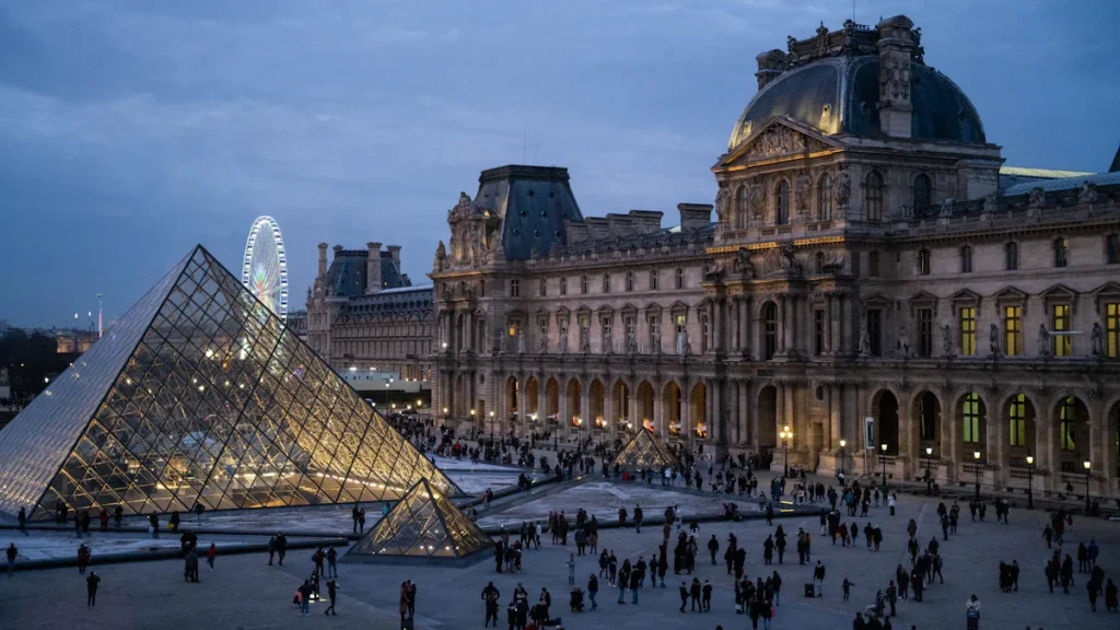 Des visiteurs devant un musée illuminé à la tombée de la nuit