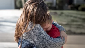 Un parent serrant son enfant dans ses bras pour le protéger et le réconforter