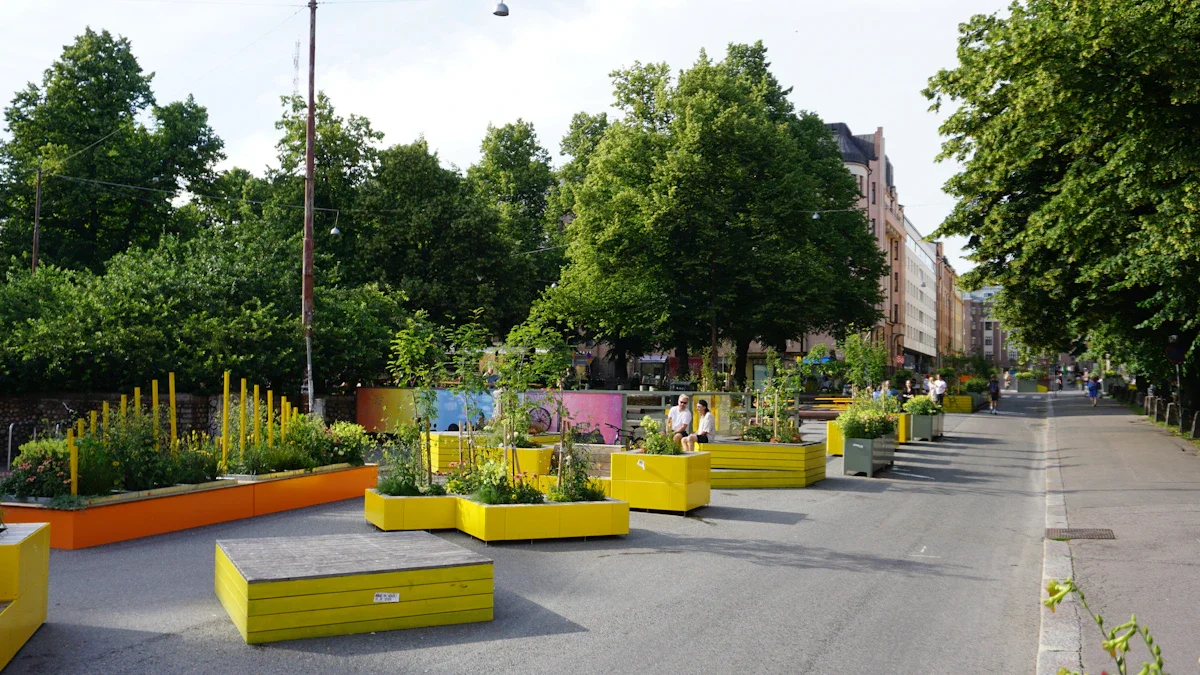 Des bacs à fleurs jaunes et oranges installés dans une rue pour créer un îlot de fraîcheur.
