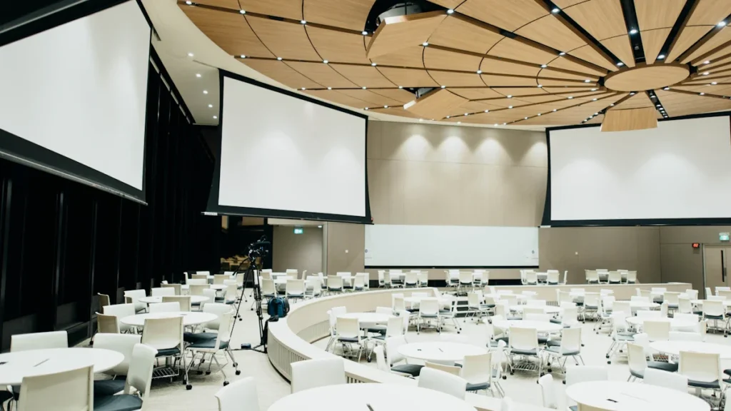 Grande salle de conférence vide prête pour accueillir le forum de l'emploi.