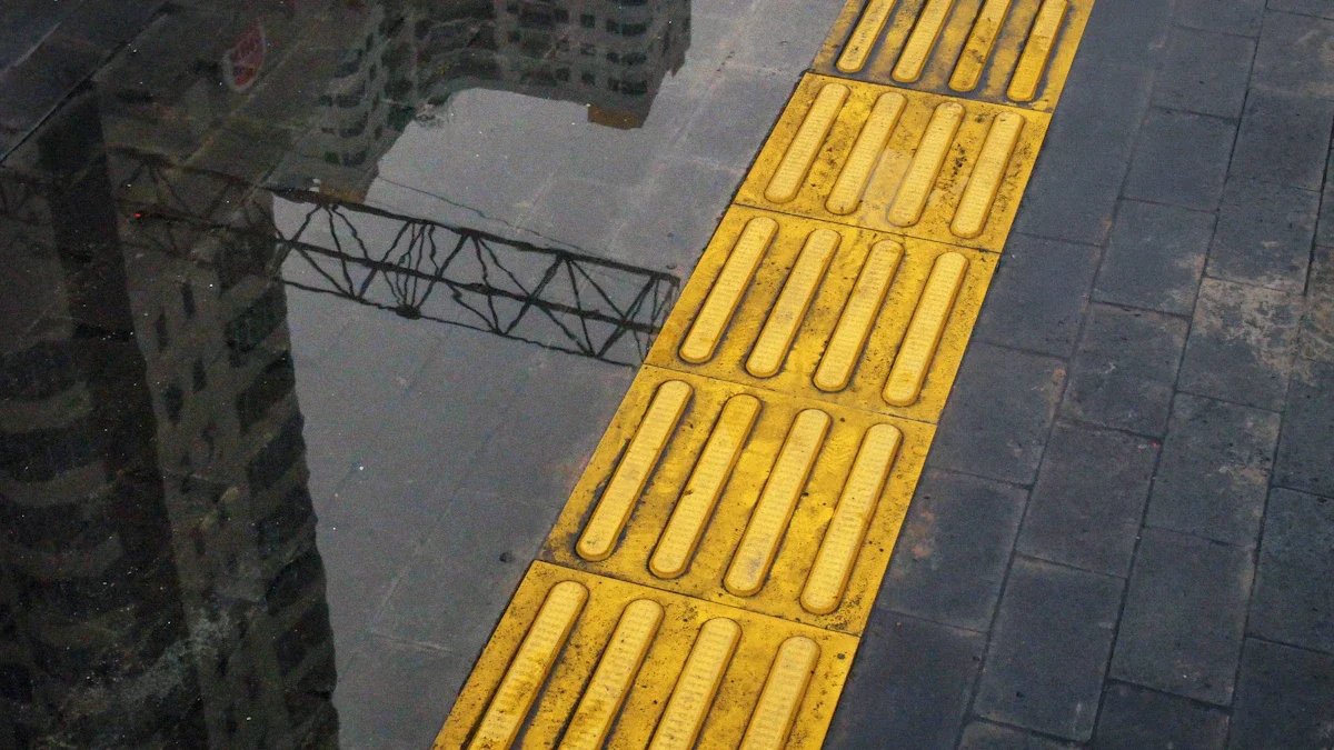 Dalle podotactile jaune sur un trottoir urbain pour faciliter l'autonomie des personnes malvoyantes.