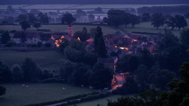 Vue nocturne d'un village provençal aux lumières chaleureuses évoquant une ambiance de fête en soirée.