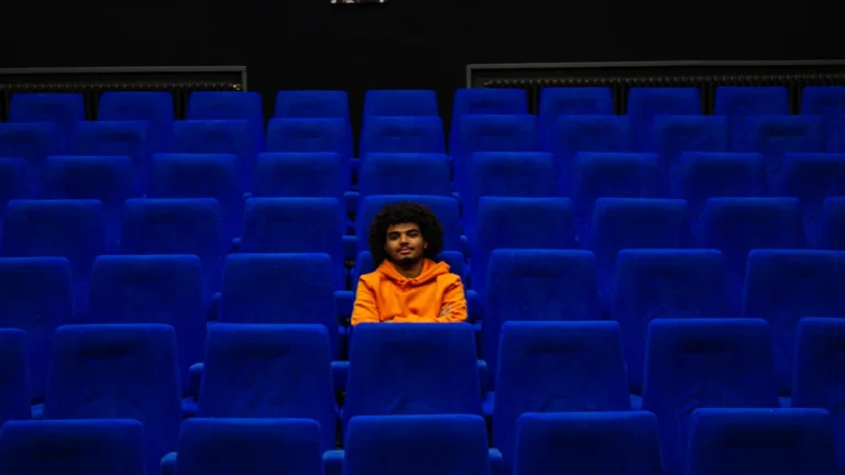 Vue de l'intérieur d'une salle de cinéma en France avec des rangées de fauteuils bleus.