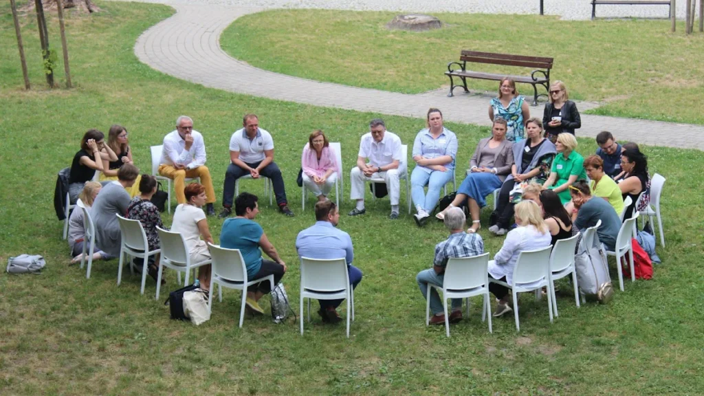 Un groupe de citoyens réunis en cercle dans un parc pour discuter de projets locaux et du budget participatif.