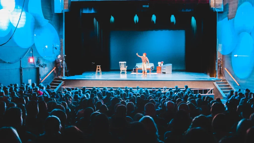 Un humoriste sur une scène nationale devant une salle comble