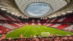 Une vue panoramique d'un stade rempli de supporters arborant des couleurs rouges et blanches pour célébrer un titre.