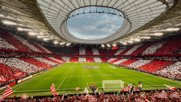 Une vue panoramique d'un stade rempli de supporters arborant des couleurs rouges et blanches pour célébrer un titre.