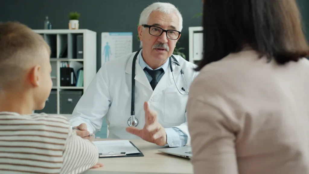 Médecin senior expliquant l'importance du don d'organes à une famille lors d'un entretien médical.