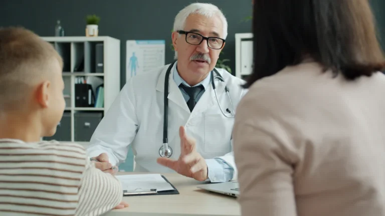 Médecin senior expliquant l'importance du don d'organes à une famille lors d'un entretien médical.