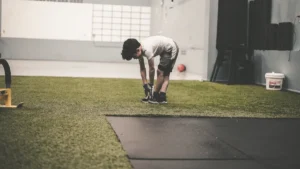 Jeune garçon s'exerçant dans une salle de sport, se préparant pour les activités physiques estivales.