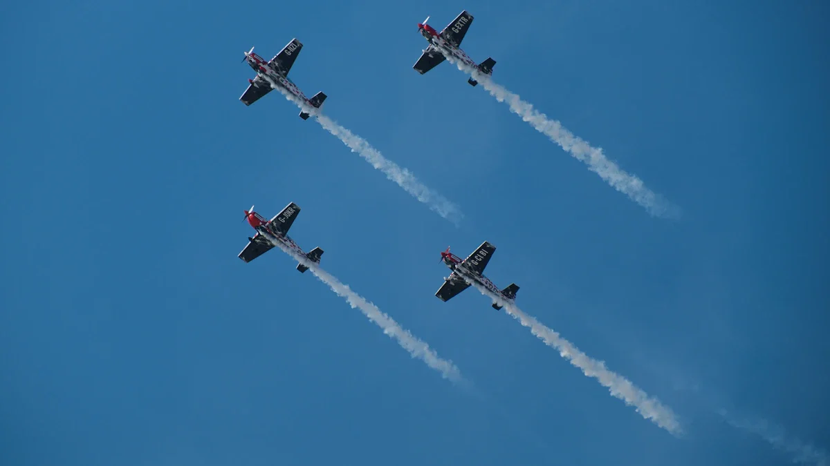 Formation de quatre avions de voltige aérienne effectuant un vol synchronisé dans un ciel bleu.