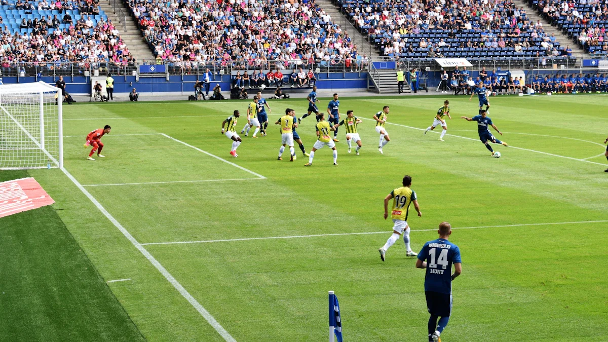 Vue d'ensemble d'un match de football disputé devant des tribunes combles dans un grand stade.