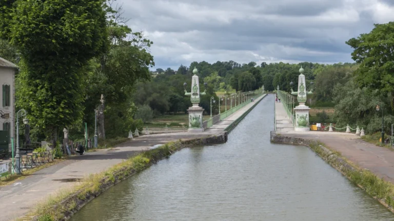 Le pont-canal de Briare avec ses colonnes ornementales traversant la Loire sous un ciel nuageux.