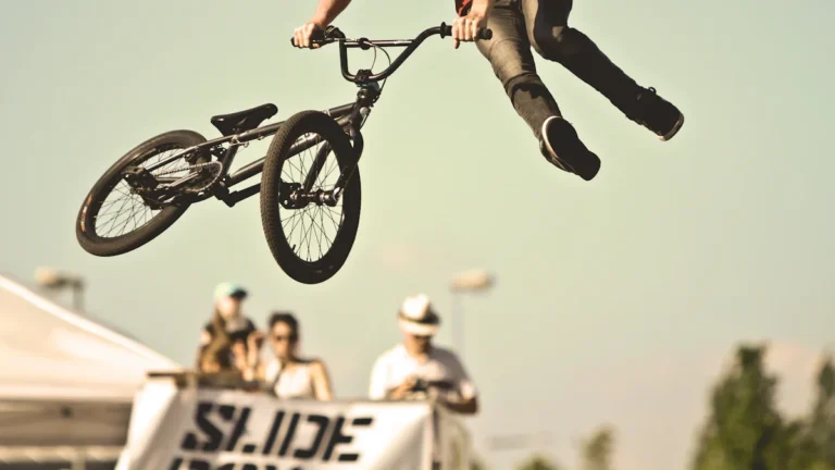 Un rider de BMX effectue une figure aérienne spectaculaire au-dessus d'une foule lors du FISE à Montpellier.
