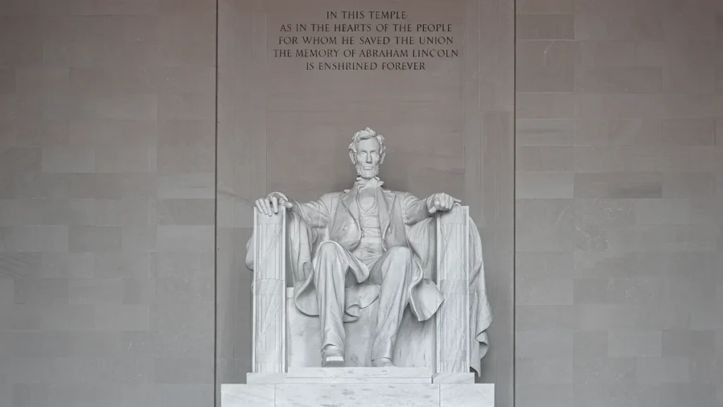 Une statue monumentale de marbre blanc symbolisant la dignité humaine et le recueillement mémoriel.