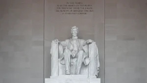 Une statue monumentale de marbre blanc symbolisant la dignité humaine et le recueillement mémoriel.