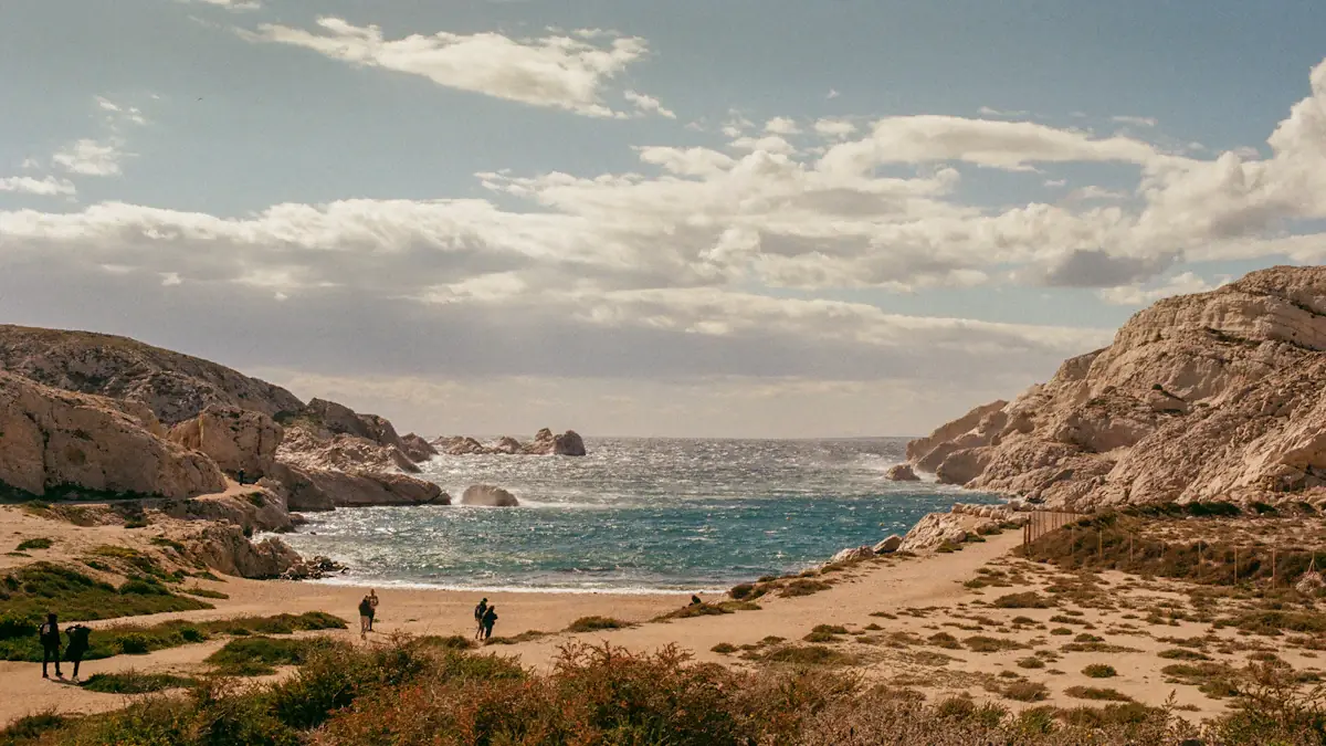 Vue panoramique d'une plage rocheuse naturelle à Marseille avec des baigneurs.