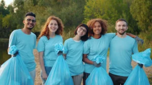 Groupe de bénévoles souriants tenant des sacs de déchets lors d'une opération de nettoyage des berges du Lez à Montpellier.