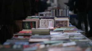 Une table couverte de livres divers présentés en plein air lors d'un festival littéraire urbain.