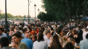 Une foule nombreuse profite d'un banquet en plein air à une terrasse animée à Paris.