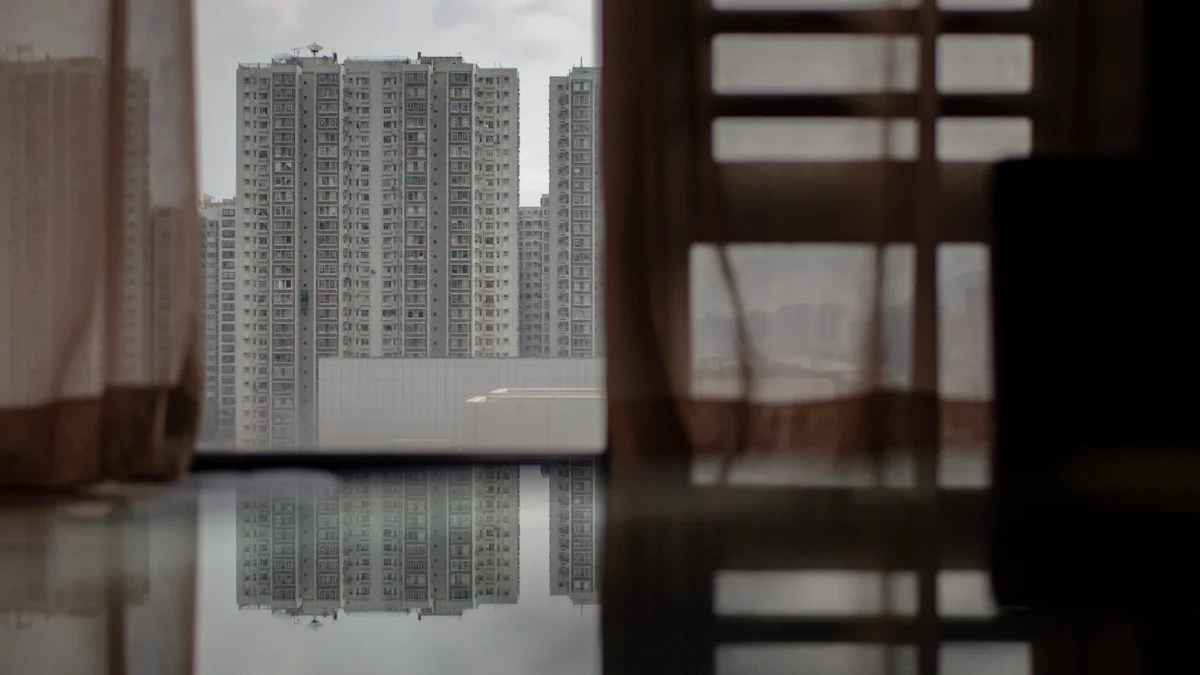 Une vue urbaine de grands immeubles modernes à travers les rideaux d'une fenêtre en intérieur.