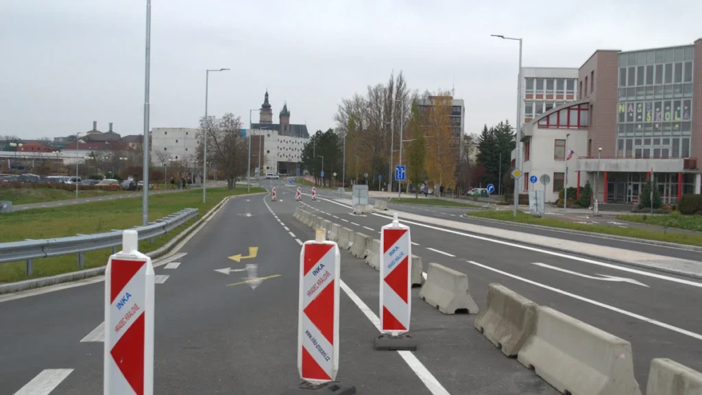 Signalisation de chantier avec balises rouges et blanches sur un boulevard urbain en cours de transformation.