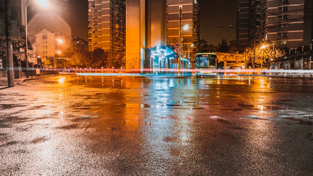 Chaussée détrempée et reflets de lumières urbaines dans une rue de ville la nuit après un orage.