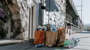 Sacs de déchets nomades entassés près d'une poubelle de rue à Orléans.