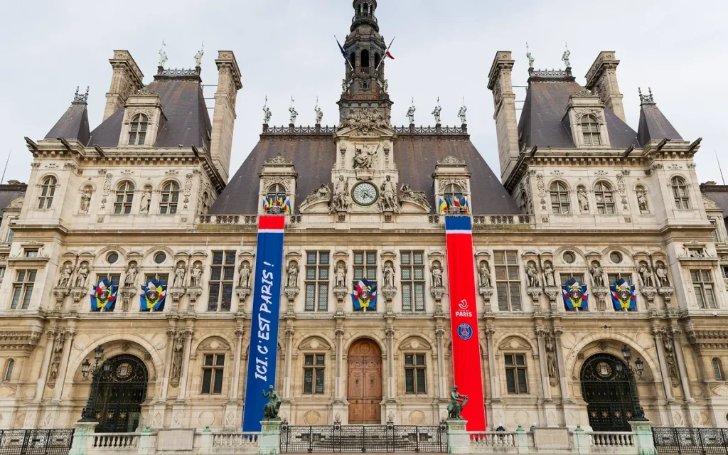 Façade de l'Hôtel de Ville de Paris ornée de deux grandes bannières verticales aux couleurs du PSG.