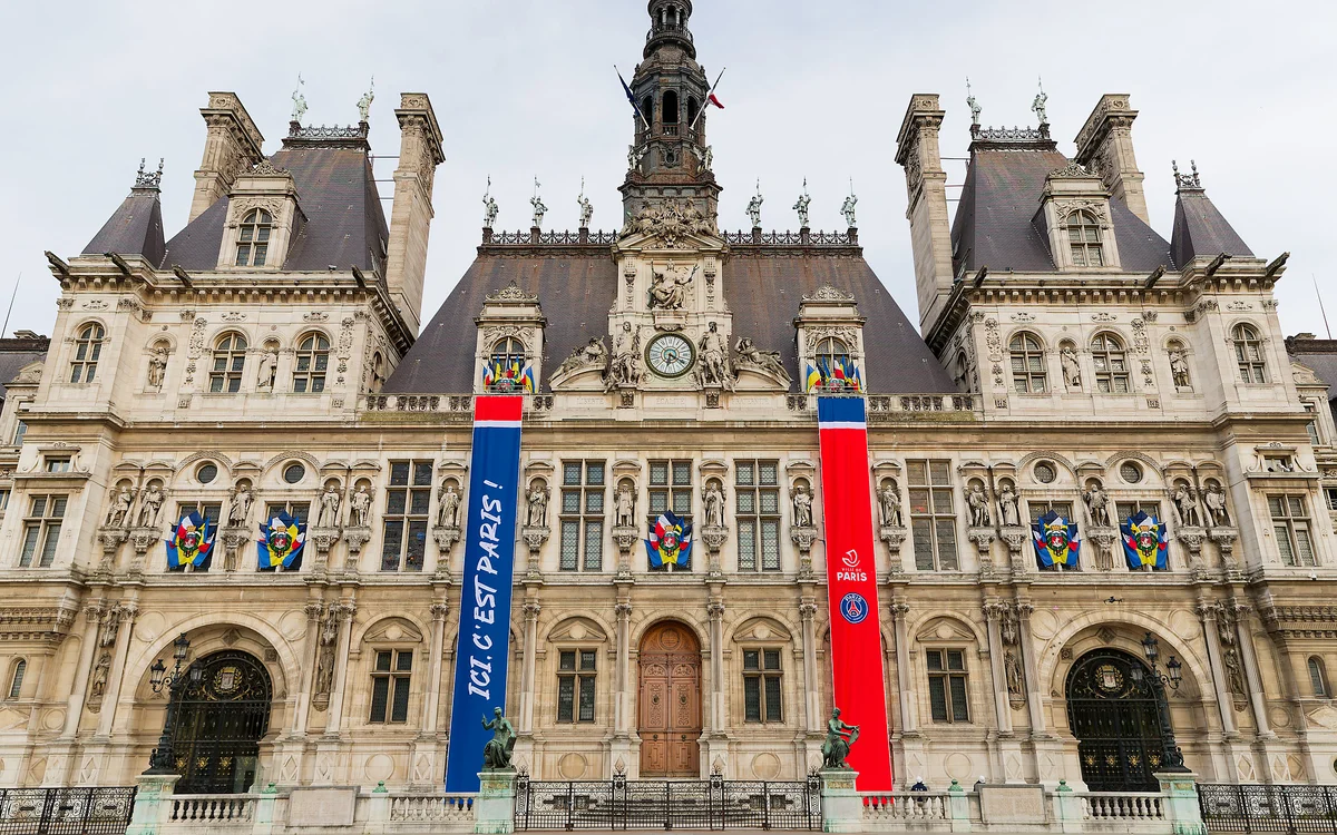 Façade de l'Hôtel de Ville de Paris ornée de deux grandes bannières verticales aux couleurs du PSG.