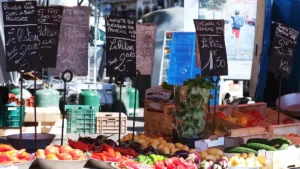 Étal de marché avec des prix affichés pour illustrer les bonnes affaires en centre-ville de Perpignan.