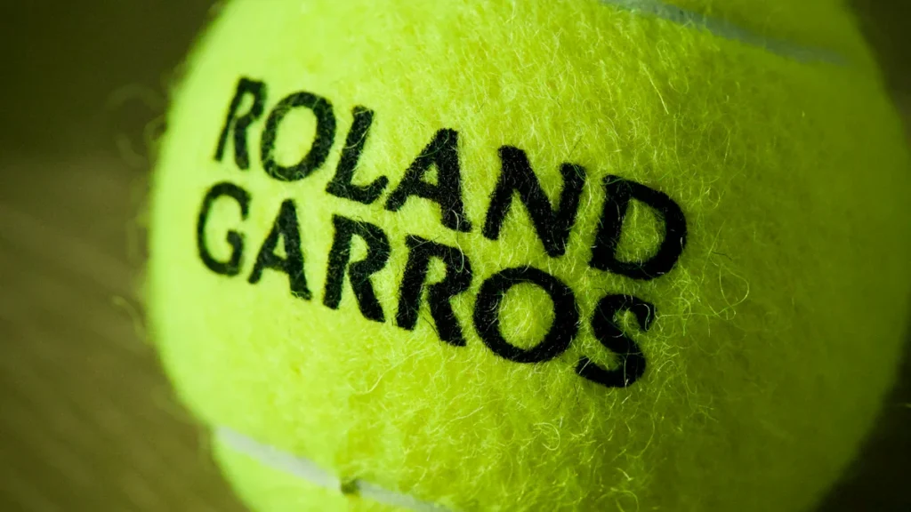 Gros plan d'une balle de tennis jaune avec le logo officiel de Roland-Garros bien visible.
