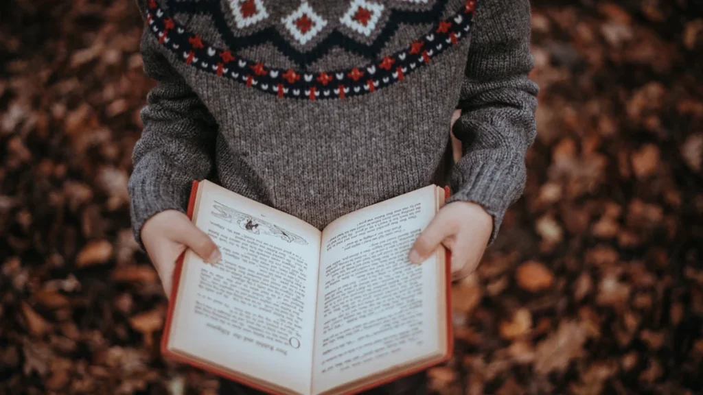 Un enfant tenant un livre ouvert, illustrant l'initiative de la ville de Saint-Denis d'offrir 16 000 livres aux écoliers.