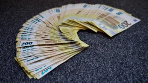 Un éventail de billets de 200 euros disposés en arc de cercle sur un fond gris.