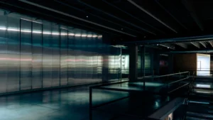 Intérieur d'un espace d'exposition moderne avec des parois métalliques évoquant un futur industriel à Saint-Étienne.