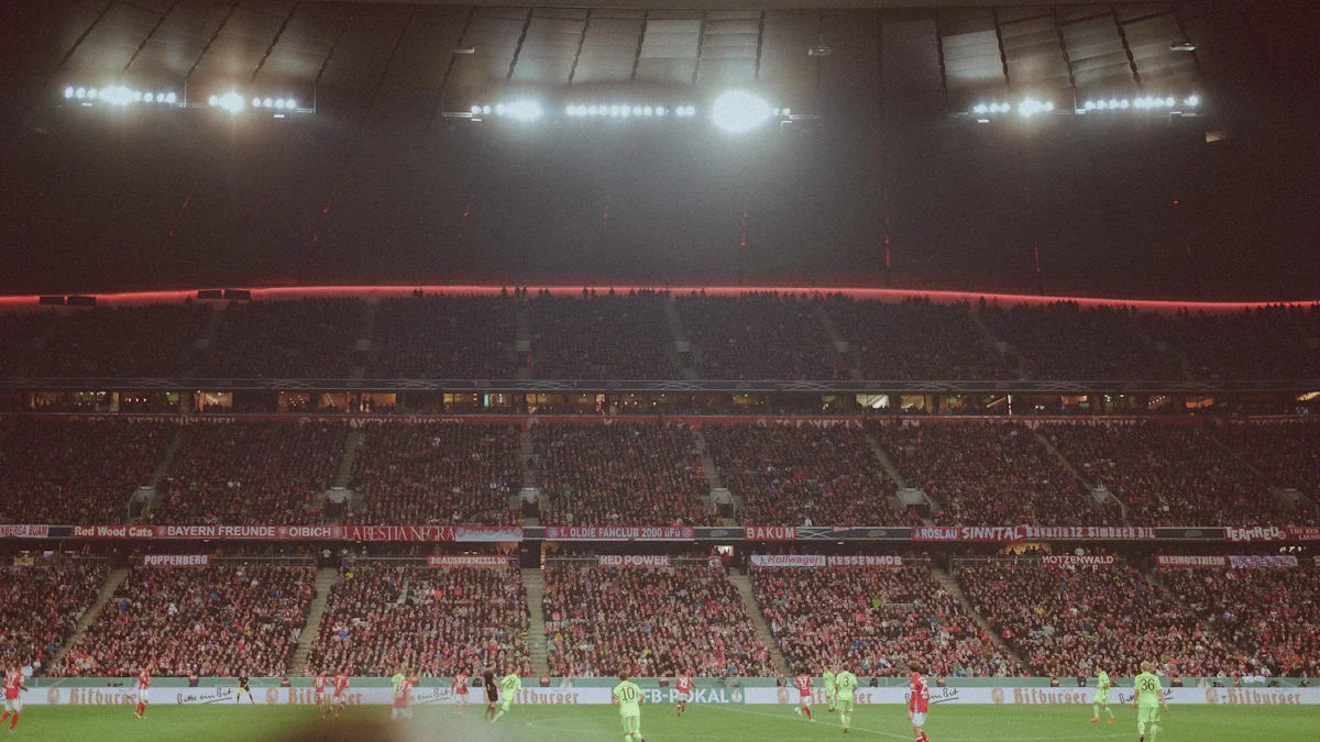 Une tribune comble vibrant au rythme d'un match de football nocturne, illustrant la ferveur retrouvée des supporters.