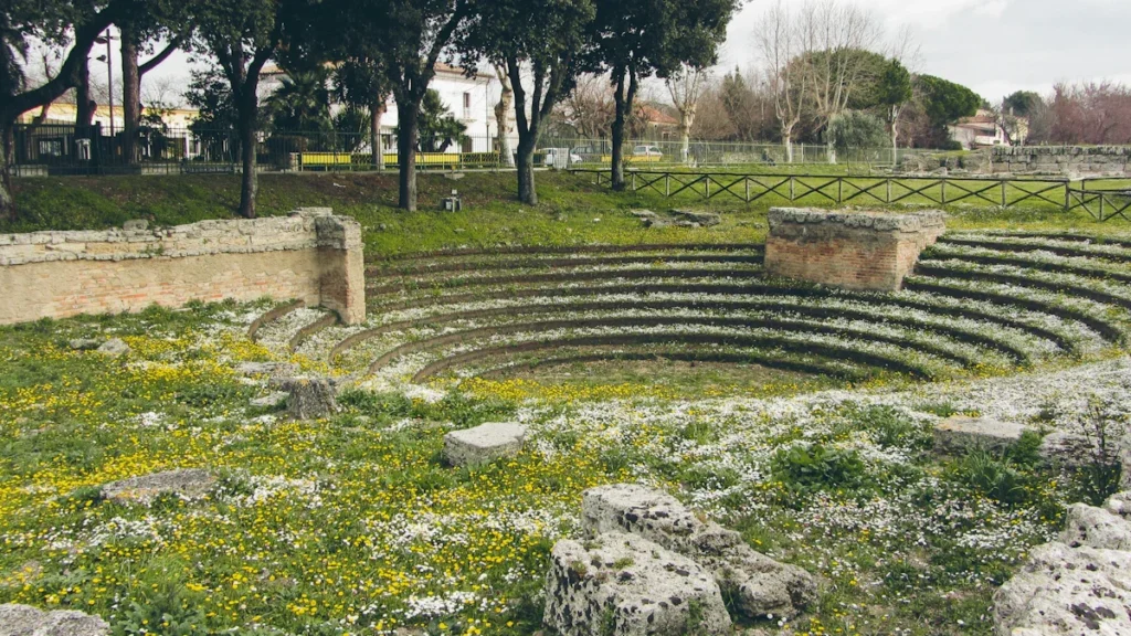 Vestiges d'un ancien lieu d'assemblée circulaire en pierre au milieu d'un champ fleuri.