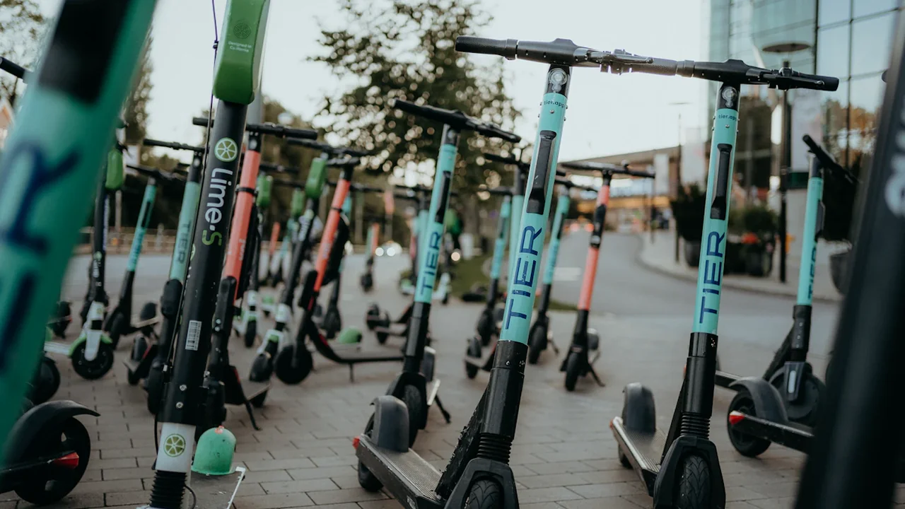 Plusieurs trottinettes électriques en libre-service stationnées sur un trottoir urbain en ville.