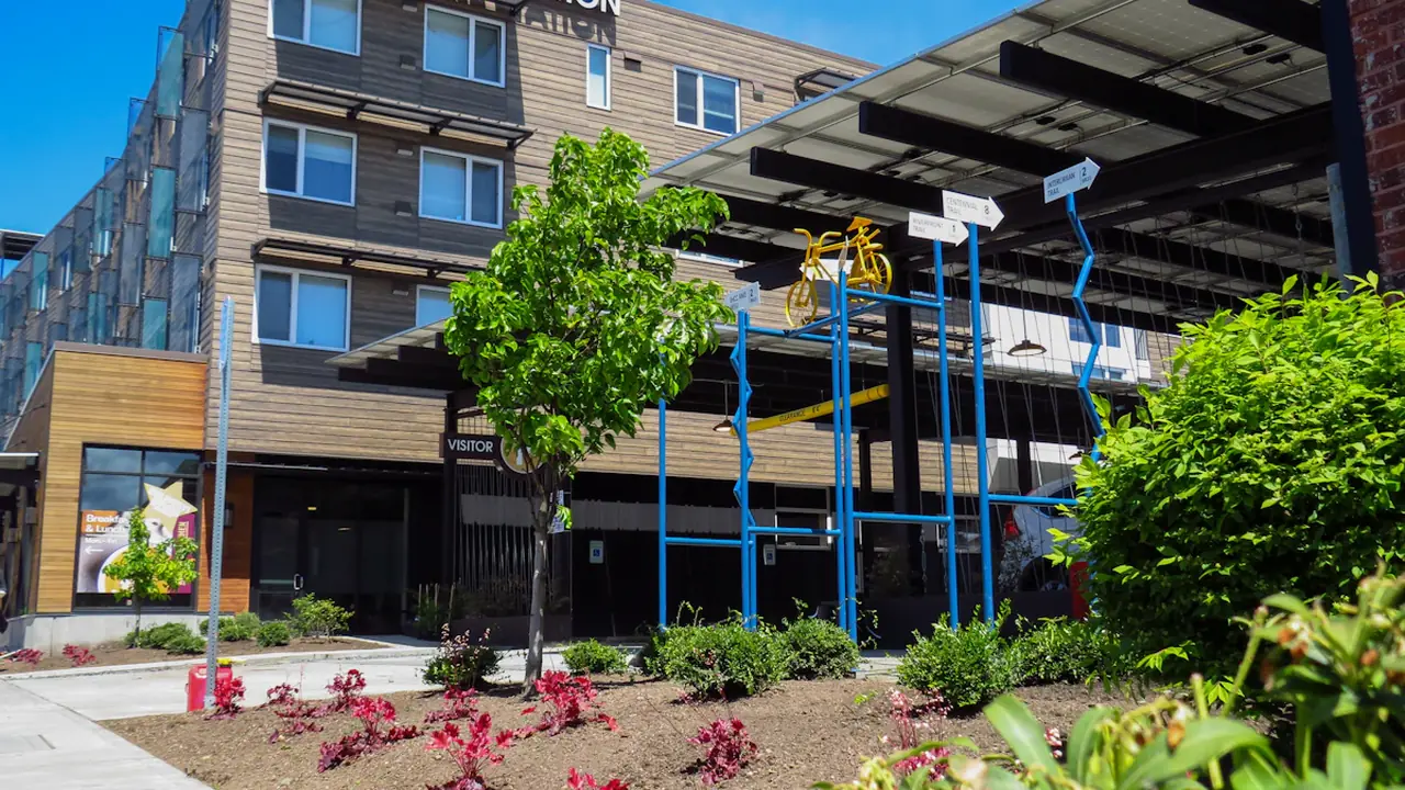Un bâtiment moderne avec un vélo stylisé devant, symbolisant la réparation et le partage.
