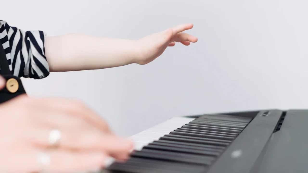 Gros plan sur les mains d'un enfant apprenant à jouer du piano