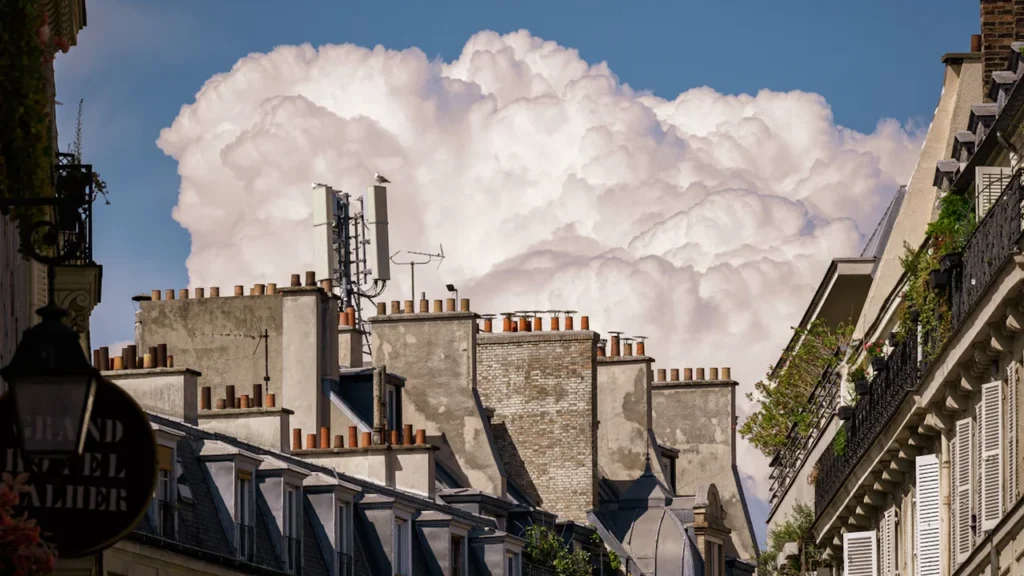 Ciel orageux menaçant surplombant les toits et cheminées traditionnelles en France.