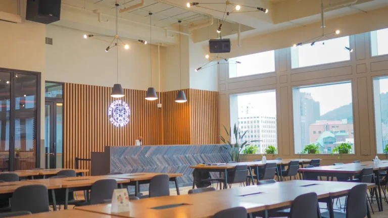 Une salle à manger moderne et lumineuse avec des tables en bois organisées.