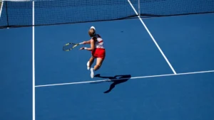 Une joueuse de tennis en action frappant une balle sur un court bleu dur.